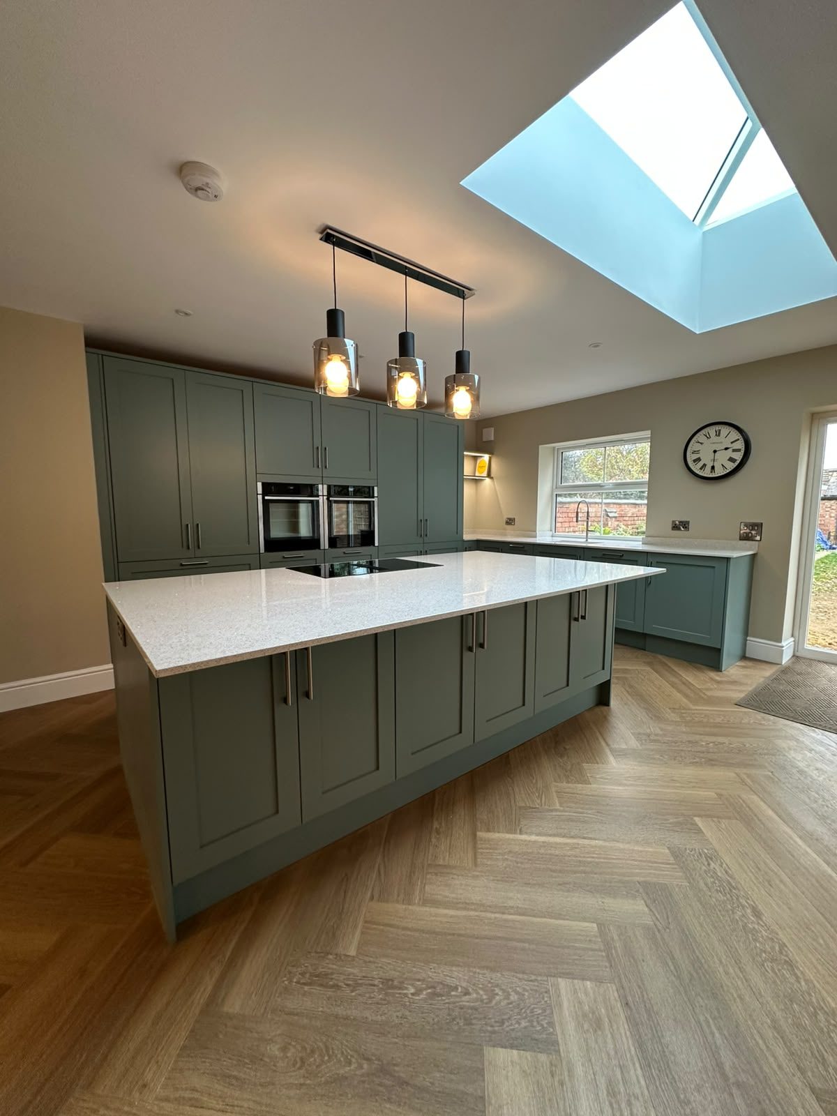 green kitchen island under a roof lantern