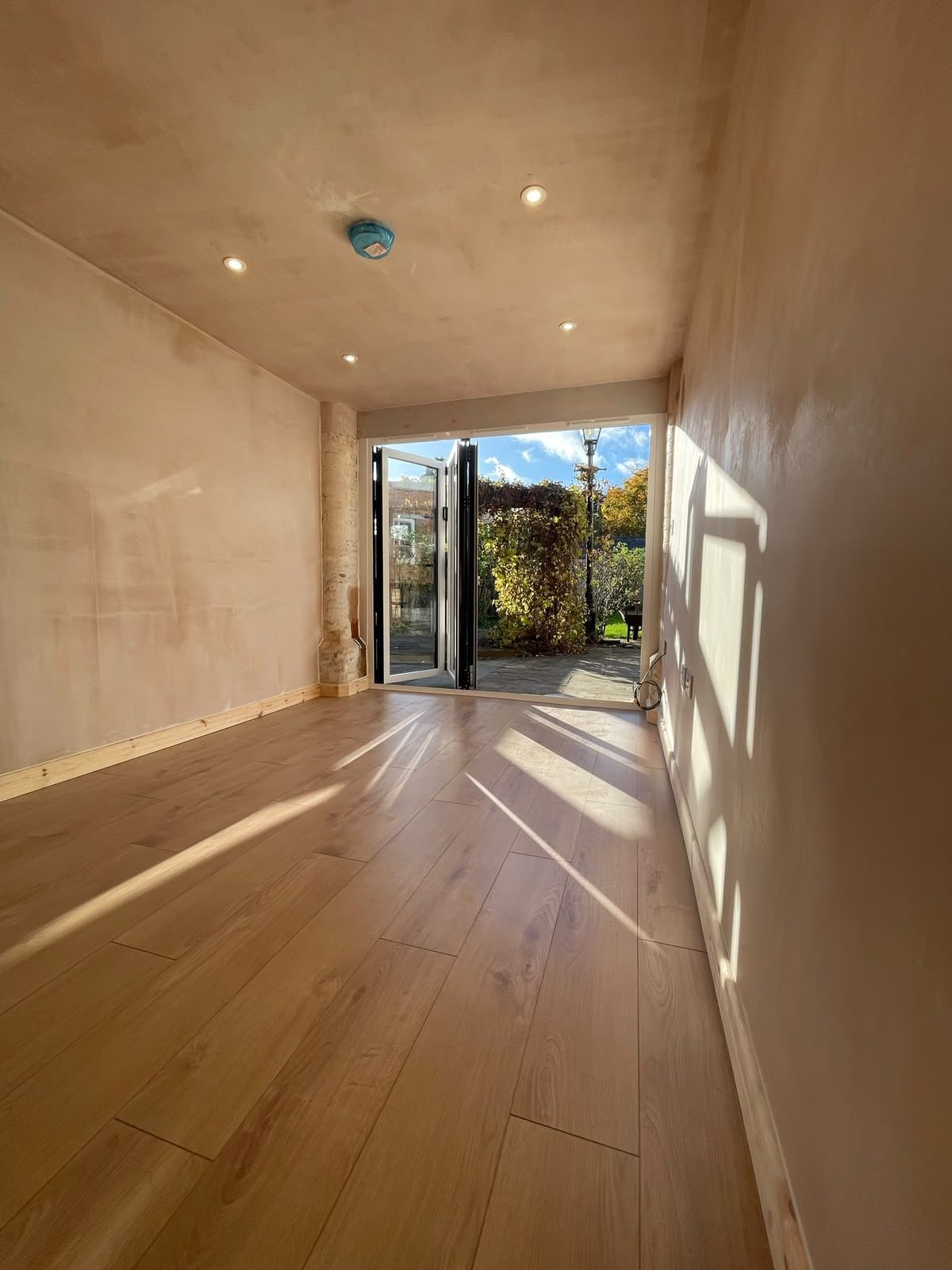 converted garage room with wood flooring