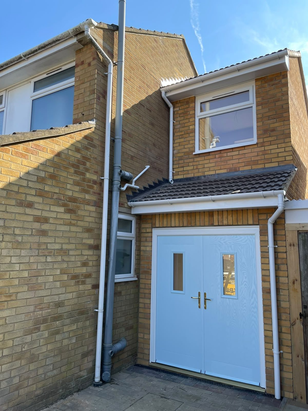 Close view of a brick entrance extension and double doors
