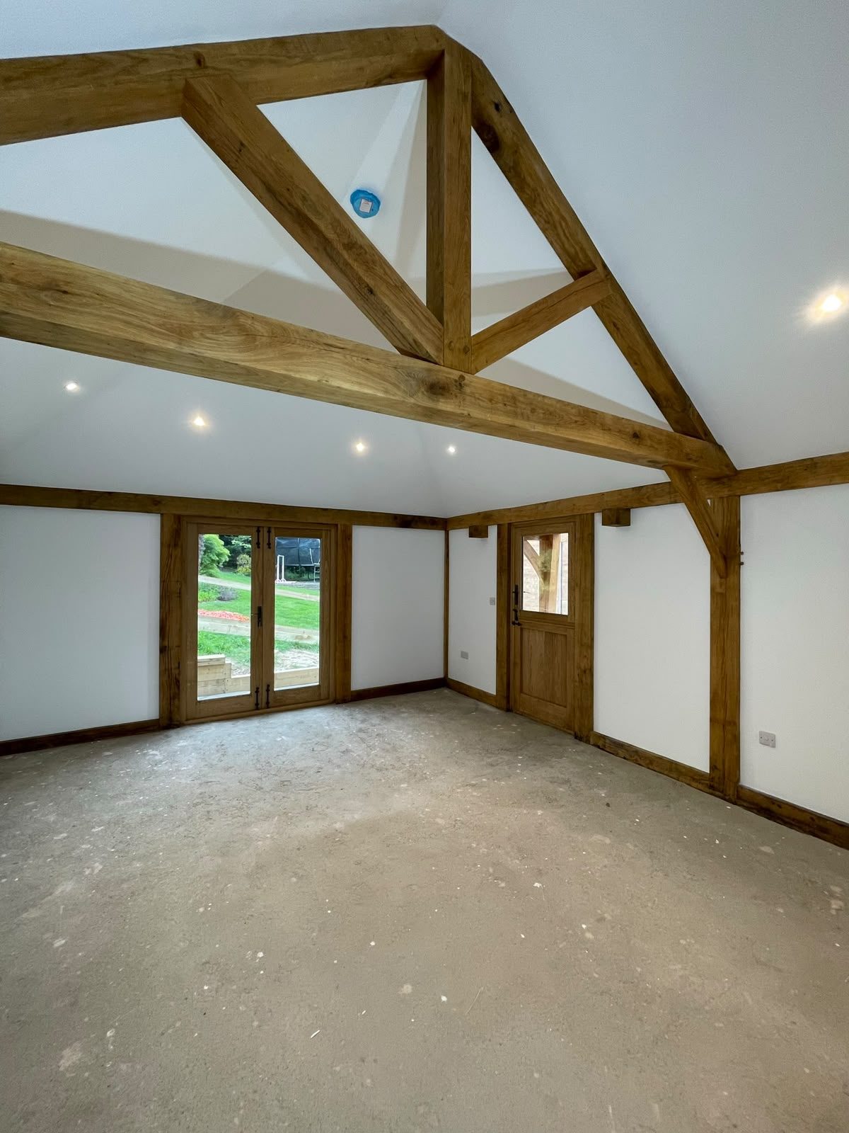 annex living room with oak trusses and French doors