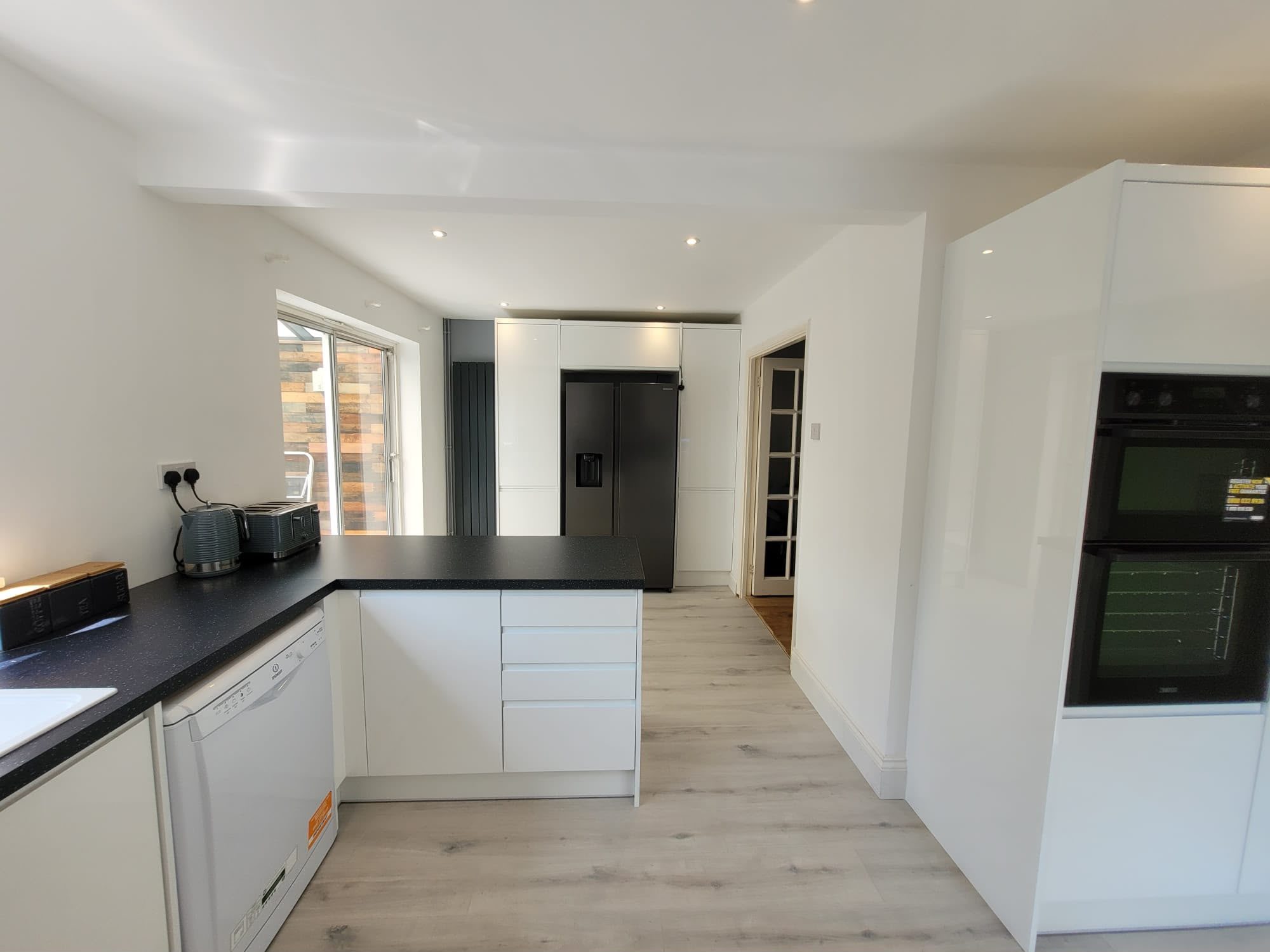 white gloss kitchen with integrated fridge