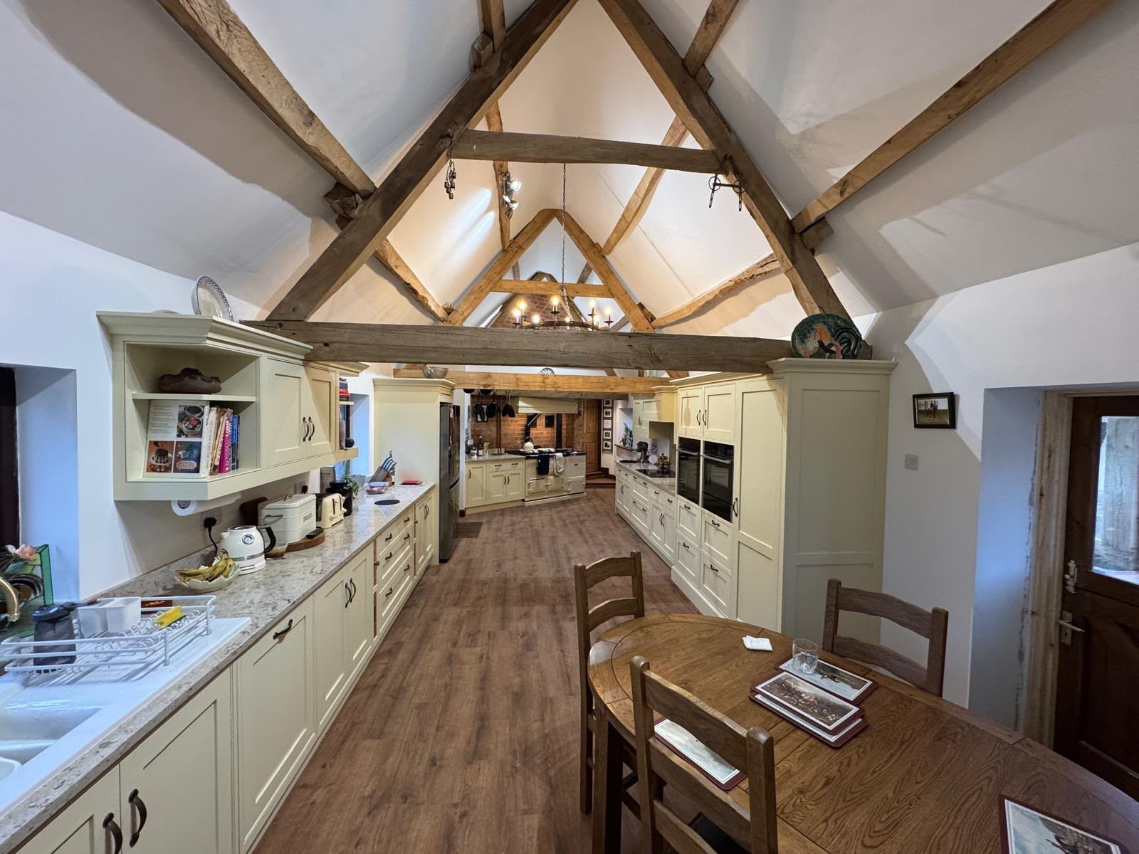 Farmhouse kitchen beneath a vaulted ceiling with exposed timber trusses