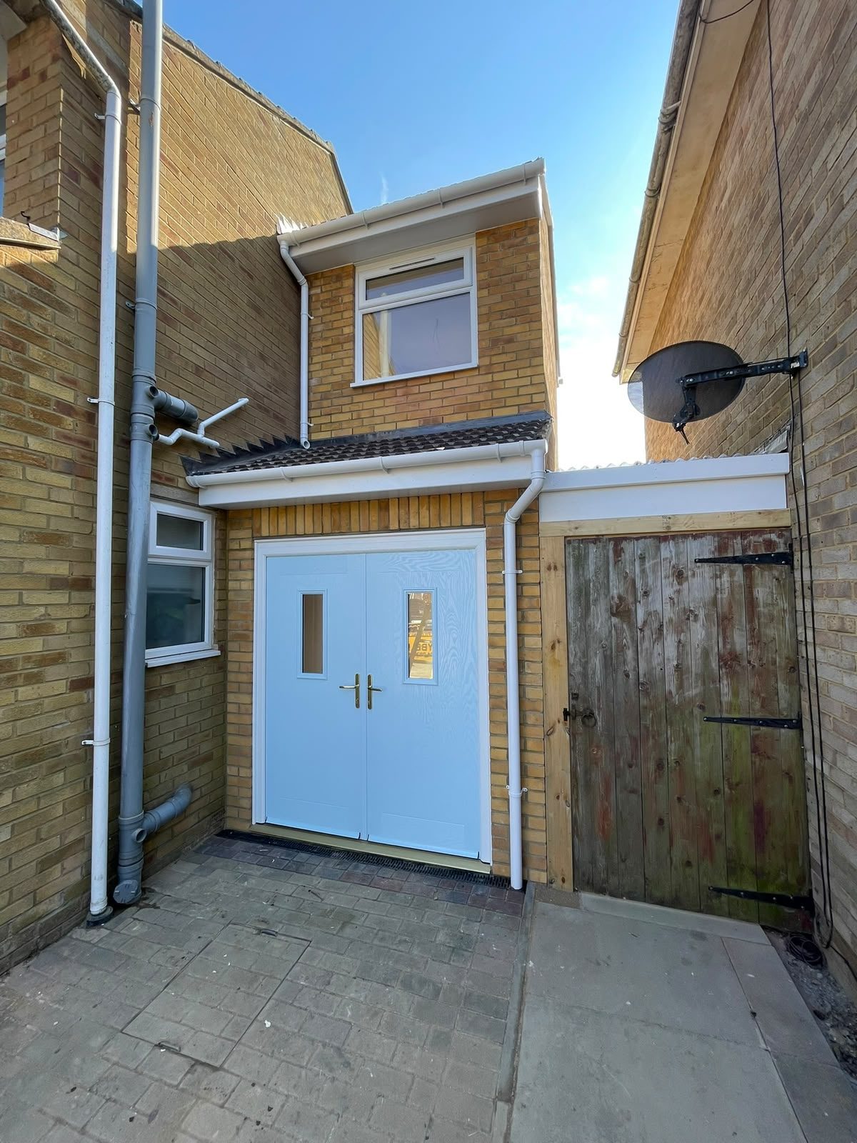 Brick entrance extension with white double doors