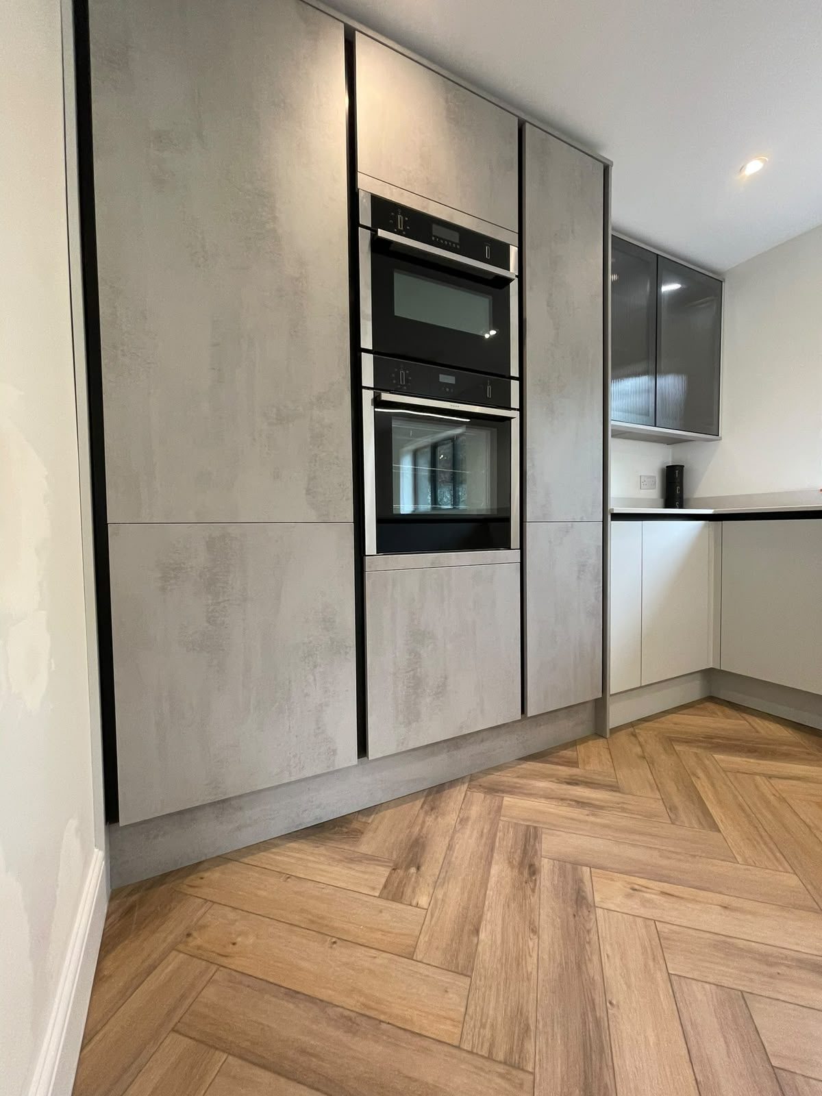 concrete-effect kitchen with built-in ovens